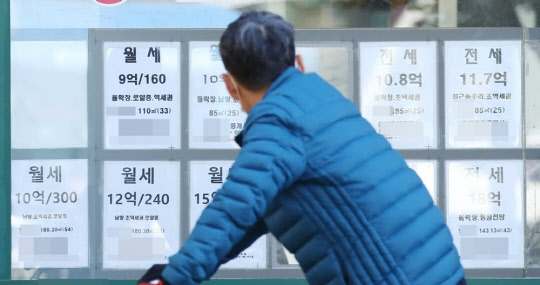 한 시민이 부동산공인중개업소 매물정보 게시판에 걸린 시세를 살펴보고 있다. <연합뉴스>